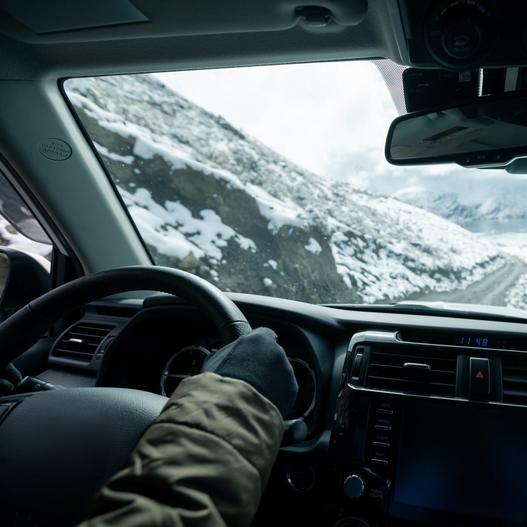 Person driving through the mountains near Durango Colorado with windshield exposed to rock chip damage and changing weather conditions.