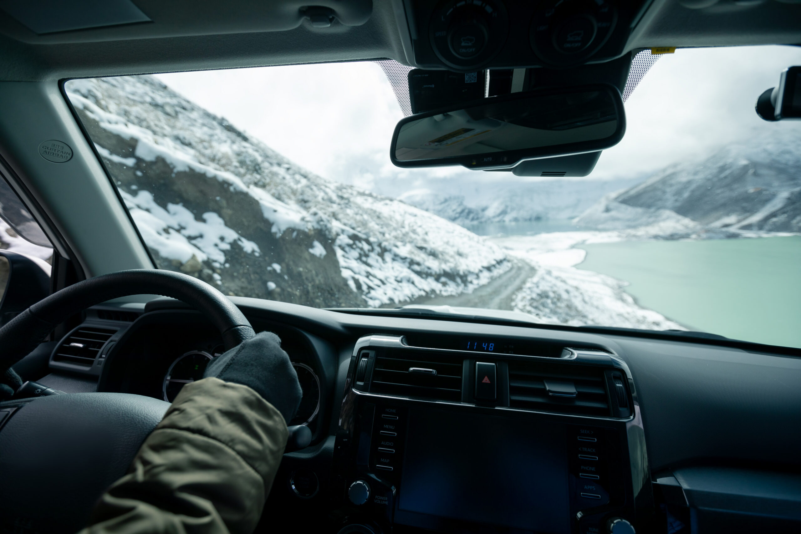 Person driving through the mountains near Durango Colorado with windshield exposed to rock chip damage and changing weather conditions.